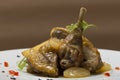 Roasted guinea fowl with potatoes, with green herbs, placed on a white plate