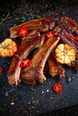 Roasted lamb cutlets ribs with garlic and herbs on stone background Royalty Free Stock Photo