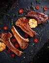 Roasted lamb cutlets ribs with garlic and herbs on stone background Royalty Free Stock Photo