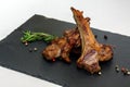 Roasted lamb ribs with rosemary and pepper on the black plate