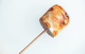 Roasted marshmallows on a skewer on white background Royalty Free Stock Photo