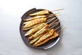 Roasted Mediterranean chicken skewers with herbs and spices, finger food snack for a festive New Year party on a dark purple plate