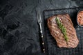 Roasted medium rare flank beef steak with thyme. Black background. Top view. Copy space Royalty Free Stock Photo