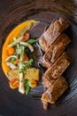 Roasted medium rare wagyu beef served with sour sauce with roasted baby vegetables on stone plate