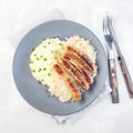 Roasted nuremberg sausages served with sour cabbage and mashed potatoes, on a gray plate, top view, square format Royalty Free Stock Photo