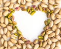 Roasted nuts on a whiroasted salted pistachio nuts on a white background and place for inscription in form of heartte background