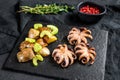 Roasted octopus. Baked potatoes and celery. Black background. Top view Royalty Free Stock Photo
