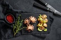 Roasted octopus. Baked potatoes  and celery. Black background. Top view Royalty Free Stock Photo
