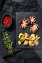 Roasted octopus. Baked potatoes and celery.  Black background. Top view Royalty Free Stock Photo