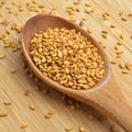 Roasted organic sesame seeds, in wooden spoon on bamboo cutting board Royalty Free Stock Photo