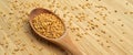 Roasted organic sesame seeds, in wooden spoon on bamboo cutting board Royalty Free Stock Photo