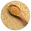 Roasted organic sesame seeds, in wooden spoon on bamboo cutting board Royalty Free Stock Photo