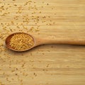 Roasted organic sesame seeds, in wooden spoon on bamboo cutting board Royalty Free Stock Photo