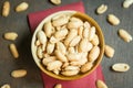 Roasted peeled salted peanuts in rustic bowl on wooden background Royalty Free Stock Photo