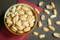 Roasted peeled salted peanuts in rustic bowl on wooden background Royalty Free Stock Photo