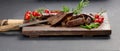 Roasted piece of beef ribeye cut into pieces on a vintage brown chopping board. Delicious steak, close up Royalty Free Stock Photo