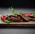 Roasted piece of beef ribeye cut into pieces on a vintage brown chopping board. Delicious steak, close up Royalty Free Stock Photo