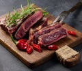 Roasted piece of beef ribeye cut into pieces on a vintage brown chopping board, rare doneness. Delicious steak Royalty Free Stock Photo