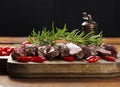 Roasted piece of beef ribeye cut into pieces on a vintage brown chopping board, rare doneness. Delicious steak, close up Royalty Free Stock Photo