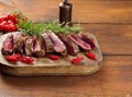 Roasted piece of beef ribeye cut into pieces on a vintage brown chopping board, rare doneness. Delicious steak, close up Royalty Free Stock Photo