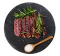 Roasted piece of beef ribeye cut into pieces on a vintage brown chopping board, rare doneness. Delicious steak, top view Royalty Free Stock Photo
