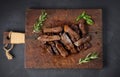 Roasted piece of beef ribeye cut into pieces on a vintage brown chopping board. Well done. Appetizing steak , top view Royalty Free Stock Photo