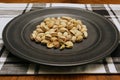 Roasted pistachio nuts on plate on plaid placemat Royalty Free Stock Photo