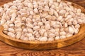 Roasted pistachio nuts on wooden dish, fragment close-up Royalty Free Stock Photo