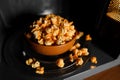 Roasted popcorn in a clay brown dish stand in the microwave