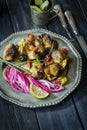 Roasted pork chops with pickled purple onions on retro metal plate on rustic table Royalty Free Stock Photo