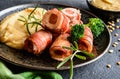 Roasted pork cutlets wrapped in bacon and stuffed with sausage, served with peas puree