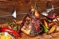 Roasted pork knuckle eisbein with braised boiled cabbage, potatoes, chili peppers and mustard on wooden cutting board Royalty Free Stock Photo