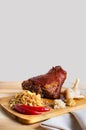 Roasted pork knuckle with stewed cabbage and vegetables on board Royalty Free Stock Photo