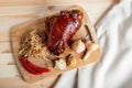 Roasted pork knuckle with stewed cabbage and vegetables on board Royalty Free Stock Photo