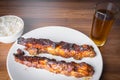 Roasted pork ribs with barbecue sauce, rice and guarana soda on a white porcelain plate with a graph and knife. Wooden table Royalty Free Stock Photo