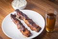 Roasted pork ribs with barbecue sauce, rice and guarana soda on a white porcelain plate. Wooden table Royalty Free Stock Photo