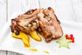 Roasted pork stuffed with mushrooms, peach, carambola, cranberries and sweet sauce on plate on wooden background