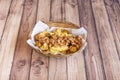 Roasted potato basket with fried chicken, bacon and sauces on wooden table Royalty Free Stock Photo