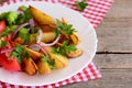 Roasted potato wedges, cooked broccoli, fresh tomato slices with spices, red onion, parsley leaves on a white plate Royalty Free Stock Photo