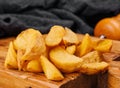 Roasted potato wedges on wooden board Royalty Free Stock Photo