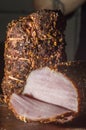 roasted prime pork joint carved and ready to serve with thyme and sage herbs. Shot against a dark rustic background. ,copy space