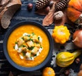 Roasted pumpkin and carrot soup with cream, crackers on dark creative wooden background. Top view. Royalty Free Stock Photo