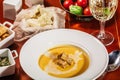 Roasted pumpkin and carrot soup with cream, pumpkin seeds. Served with croutons, cheese and white wine on wooden background. Copy Royalty Free Stock Photo