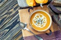 Roasted pumpkin soup with cream, fresh pumpkins and pumpkin seeds in plate on wooden background. Copy space Royalty Free Stock Photo