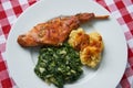 Roasted rabbit leg, marinated in garlic and rosemary served with spinach and potato dumplings Royalty Free Stock Photo