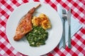 Roasted rabbit leg, marinated in garlic and rosemary served with spinach and potato dumplings Royalty Free Stock Photo