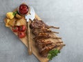 Roasted rack lamb chops on a wooden board with asparagus, red sauce, potatoes Royalty Free Stock Photo