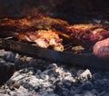 Roasted red meat over the grill in a traditional Argentinian asado. Close up detail