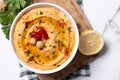 Roasted red pepper hummus in white bowl on white marble background Royalty Free Stock Photo