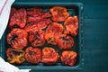 Roasted red peppers in baking tray on black wooden background. Top view Royalty Free Stock Photo